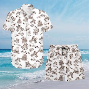 May include: White button-down shirt and matching shorts set. The set features a repeating pattern of brown otters, palm trees, and islands. The shirt has short sleeves and a classic collar. The shorts have a drawstring waist.