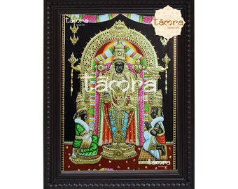 May include: A framed painting of a Hindu deity with a black face and gold jewelry, surrounded by flowers and other decorative elements. The painting is set against a black background and framed in a dark wood frame.
