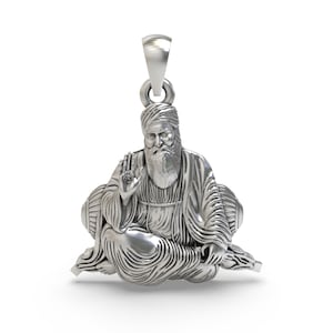 Peut inclure: Pendentif en argent représentant une sculpture détaillée d'une figure assise avec une barbe et un turban. La figure lève une main avec un symbole sur la paume.