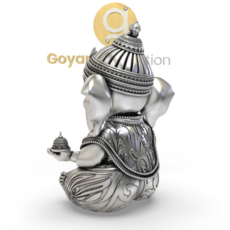 May include: A silver-colored statue of the Hindu deity Ganesha, seated with intricate details. The statue features a detailed headdress, ornate clothing, and a small offering in one hand. The image includes the text "Goyan Creation".