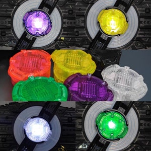 May include: A set of eight colorful plastic toy pieces with a circuit board design. The pieces are in various colors, including red, yellow, green, purple, and clear. The pieces are arranged in a grid pattern.