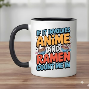 May include: White ceramic mug with a black handle and rim. The mug features the text "IF IT INVOLVES ANIME AND RAMEN COUNT ME IN" in a colorful design with images of ramen bowls and chopsticks. The mug is on a wooden surface.