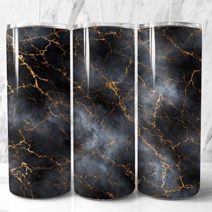 Könnte beinhalten: Drei Edelstahlbecher mit schwarzem Marmordesign und goldfarbenen Adern. Die Becher haben eine schlanke, zylindrische Form und sind mit transparenten Deckeln und Strohhalmen versehen. Das Marmormuster verleiht den Bechern ein luxuriöses Aussehen.