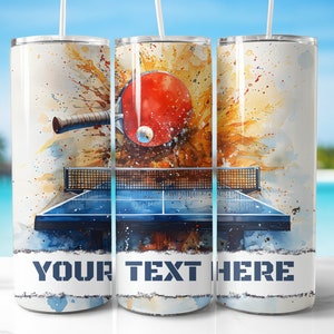 May include: A white stainless steel tumbler with a watercolor design of a ping pong table and paddle. The text "YOUR TEXT HERE" is printed on the tumbler.