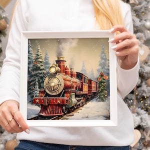 K&ouml;nnte beinhalten: Eine gerahmte Illustration eines roten, alten Dampfloks, die durch einen schneebedeckten Wald f&auml;hrt. Die Lokomotive hat goldene Akzente und ist mit Sternen verziert. Die Illustration ist vor dem Hintergrund eines schneebedeckten Waldes mit Kiefern.