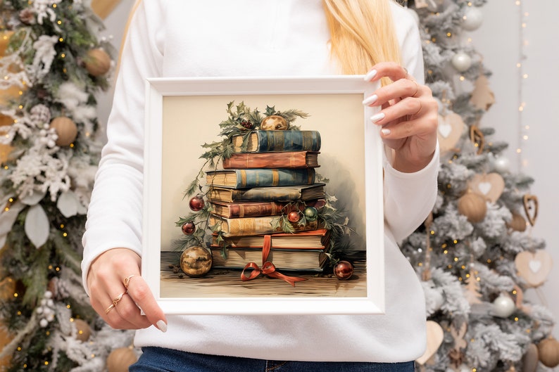 K&ouml;nnte beinhalten: Ein gerahmtes Gem&auml;lde mit einem Stapel antiker B&uuml;cher, die mit Stechpalme und roten Beeren verziert sind. Die B&uuml;cher sind mit einem roten Band zusammengebunden und obenauf befinden sich goldene Ornamente.