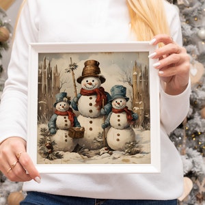 K&ouml;nnte beinhalten: Eine gerahmte Illustration von drei Schneem&auml;nnern, die in einer verschneiten Winterlandschaft stehen. Die Schneem&auml;nner tragen H&uuml;te und Schals, und der gr&ouml;&szlig;te Schneemann h&auml;lt einen Besen. Die Illustration ist im Vintage-Stil mit gedeckten Farben gemalt.