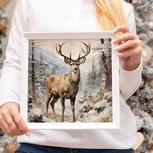 K&ouml;nnte beinhalten: Ein gerahmtes Gem&auml;lde eines braunen Hirsches mit Geweih, der in einem schneebedeckten Wald steht. Der Hirsch blickt direkt auf den Betrachter. Das Gem&auml;lde zeigt einen Hintergrund aus schneebedeckten B&auml;umen und Bergen.