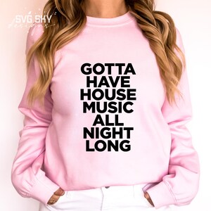 K&ouml;nnte beinhalten: Ein rosa Sweatshirt mit dem Text "GOTTA HAVE HOUSE MUSIC ALL NIGHT LONG" in Schwarz gedruckt.
