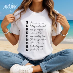 May include: White t-shirt with the word "SURRENDER" spelled vertically down the front. The word is defined as "Surrender means letting go of control and ego, embracing vulnerability, and accepting help. This transformative act paves the way for healing and spiritual growth."