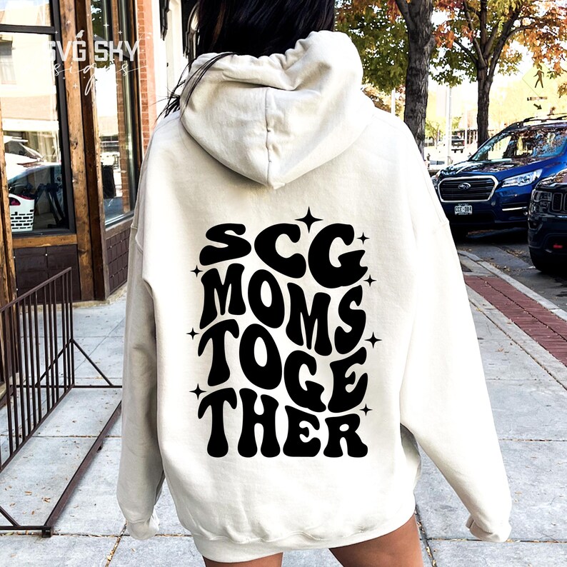 May include: A white hoodie with a black graphic on the back that says "SCG MOMS TOGE THER" in a retro font.