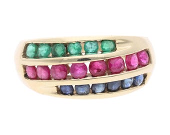 Op de afbeelding: Een gouden ring met drie rijen edelstenen. De bovenste rij heeft groene stenen, de middelste rij roze stenen en de onderste rij blauwe stenen. De ring heeft een gebogen ontwerp.