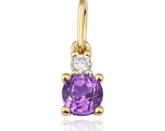 Pode incluir: Um pingente de ouro com uma gema de ametista roxa e uma gema de diamante transparente menor.