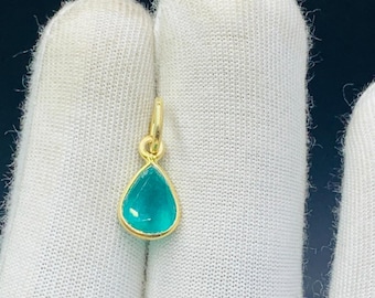 May include: A teardrop-shaped pendant with a light blue gemstone set in gold.