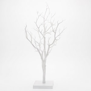 May include: A matte white decorative tree sculpture featuring a central trunk that branches out into numerous thin, bare twigs. The entire structure is mounted on a solid, square white base, creating a stark and uniform monochromatic appearance.