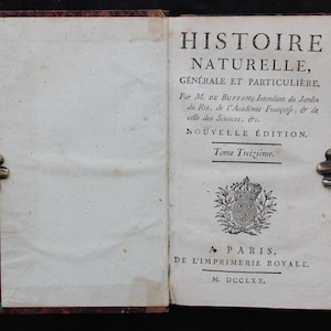 Op de afbeelding: Een open antiek boek met de titel Histoire Naturelle, Générale et Particulière, Tome Treizième, uitgegeven in Parijs in 1770. De rechterpagina bevat zwarte gedrukte tekst en een koninklijk embleem met een kroon en lelies.
