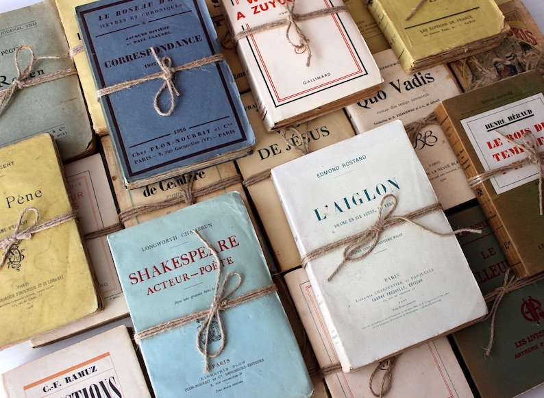Puede incluir: Una colecci&oacute;n de libros antiguos de tapa dura con cuerda marr&oacute;n atada alrededor. Los libros tienen t&iacute;tulos en franc&eacute;s, incluyendo "Le Roseau", "Correspondance", "L'Aiglon" y "Le Bois de Temps Perdu".