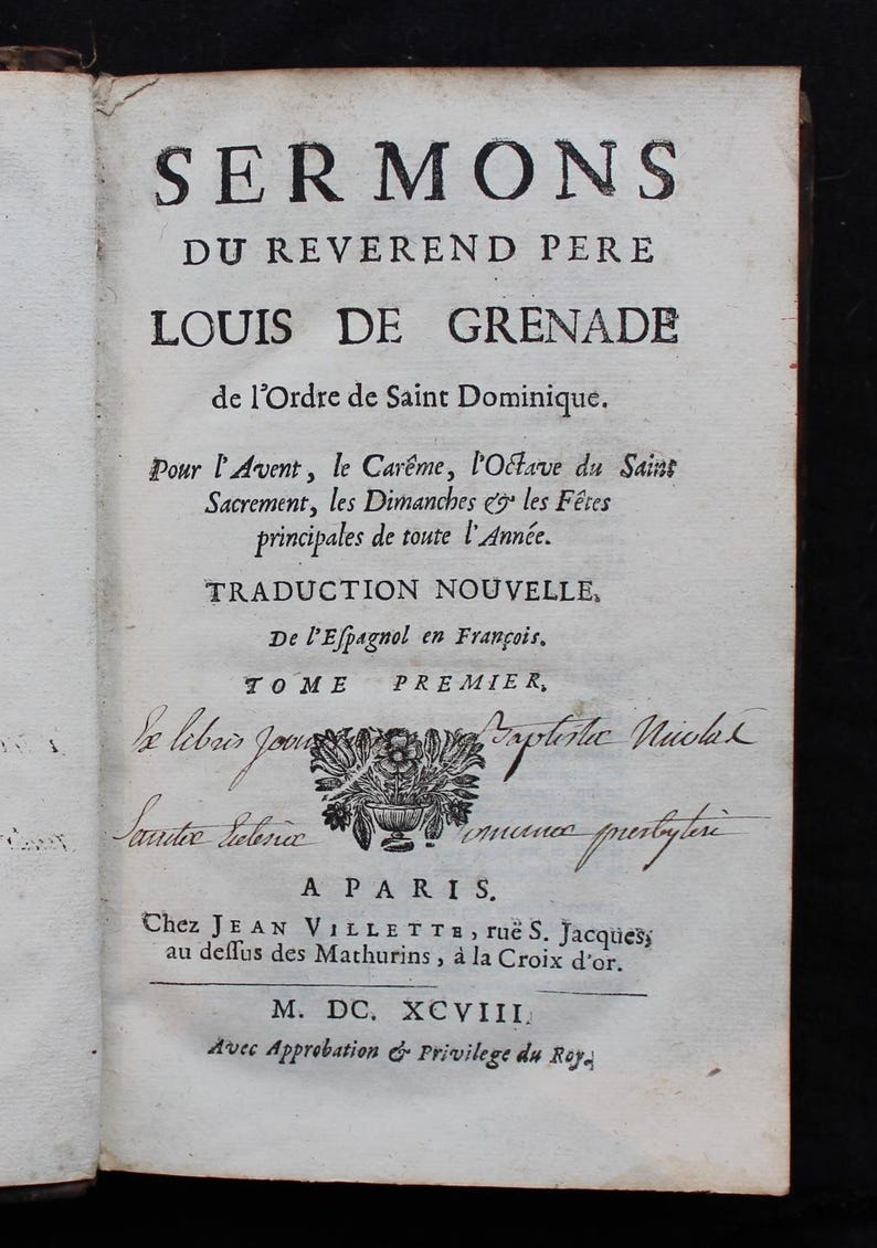 May include: An open book page with black text. The title reads "SERMONS" above the name "LOUIS DE GRENADE." Additional text describes the book's contents and publisher. The page has a floral illustration and handwritten notes.