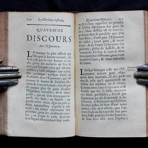 Pode incluir: Um livro antigo aberto com uma capa de couro marrom e p&aacute;ginas amareladas. O livro &eacute; intitulado "Le Chr&eacute;tien Infruit, Quatri&egrave;me Discours Sur l'Esperance". O texto nas p&aacute;ginas est&aacute; em franc&ecirc;s.