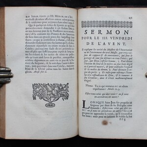 May include: An open antique book with text and illustrations, held by bronze hands. The pages display French text, with the title "SERMON POUR LE III VENDREDI DE L'AVENT."