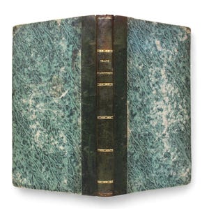 Peut inclure: Livre ancien avec une couverture marbrée turquoise et un dos vert foncé. Le dos présente des lettres dorées et des éléments décoratifs. Le titre "TRAITE D'ABONNEMENT" est visible. Le livre est ouvert, révélant les pages intérieures.