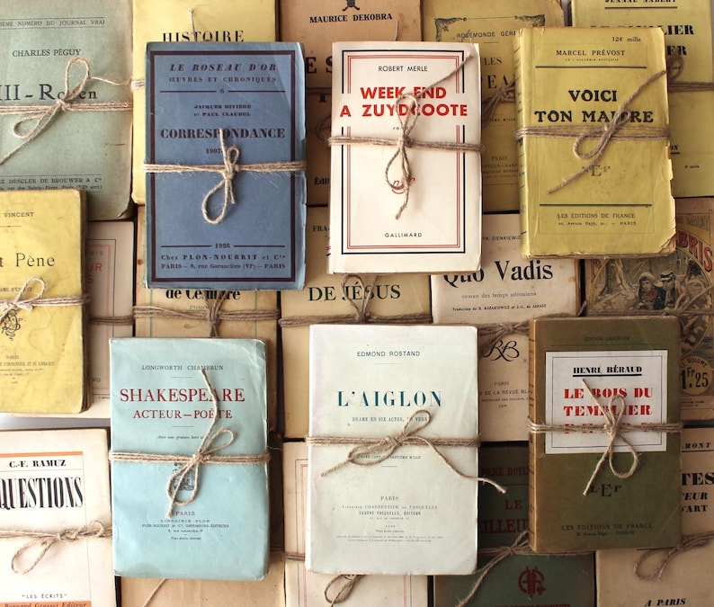 Puede incluir: Una colecci&oacute;n de libros antiguos con cubiertas de papel marr&oacute;n y cuerda atada alrededor de ellos. Los libros tienen t&iacute;tulos franceses y est&aacute;n apilados en una pila.
