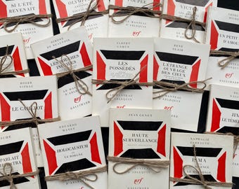 May include: A selection of vintage French books, tied with twine. The covers display a striking design with black, red, and white geometric shapes, and titles in French.