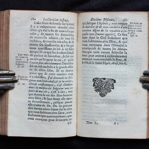 Pode incluir: Um livro aberto com uma ilustra&ccedil;&atilde;o em preto e branco de um p&aacute;ssaro com uma coroa na cabe&ccedil;a. O livro est&aacute; aberto em uma p&aacute;gina com texto em franc&ecirc;s. O texto na p&aacute;gina diz "Sixi&egrave;me Discours".
