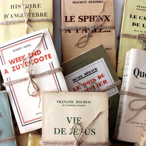 Puede incluir: Una colecci&oacute;n de libros antiguos con cubiertas de papel marr&oacute;n y cuerda atada alrededor de ellos. Los t&iacute;tulos de los libros incluyen "Histoire d'Angleterre", "Le Sphinx", "Le Cavalier de la Mer", "Week End a Zuydcoote", "Le Bois du Somme", "Quo Vadis", y "Vie de Jesus".