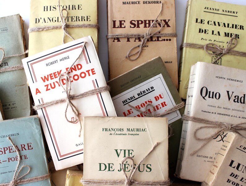 Puede incluir: Una colecci&oacute;n de libros antiguos con cubiertas de papel marr&oacute;n y cuerda atada alrededor de ellos. Los t&iacute;tulos de los libros incluyen "Histoire d'Angleterre", "Le Sphinx", "Le Cavalier de la Mer", "Week End a Zuydcoote", "Le Bois du Somme", "Quo Vadis", y "Vie de Jesus".