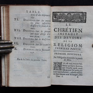 Pode incluir: Um livro antigo intitulado "Le Chretien Instruit des Devoirs de sa Religion. Premiere Partie." com uma tabela de conte&uacute;do listando dez cap&iacute;tulos. O livro est&aacute; aberto no primeiro cap&iacute;tulo, "Premier Discours. Sur l'Obligation d'entendre la parole de Dieu."