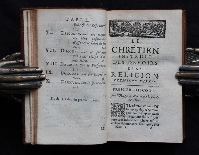 Pode incluir: Um livro antigo intitulado "Le Chretien Instruit des Devoirs de sa Religion. Premiere Partie." com uma tabela de conte&uacute;do listando dez cap&iacute;tulos. O livro est&aacute; aberto no primeiro cap&iacute;tulo, "Premier Discours. Sur l'Obligation d'entendre la parole de Dieu."