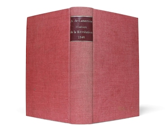 Könnte beinhalten: Ein Vintage-Buch mit rotem Einband. Der Buchrücken zeigt ein dunkelweinrotes Etikett mit dem Titel "Histoire de la Révolution 1848" und dem Namen des Autors. Der Einband des Buches hat eine strukturierte Oberfläche.