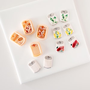 Può includere: Un set di 10 stampini per biscotti a forma di lattine di cibo. Gli stampini sono in plastica e di vari colori, tra cui rosso, verde, giallo e arancione. Gli stampini presentano diversi alimenti, come mais, piselli e pomodori.