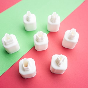 May include: A collection of six white plastic cookie cutters, each featuring a distinct geometric or floral-inspired shape on the top surface. The cutters are arranged in a circular pattern, showcasing varied intricate designs for baking.