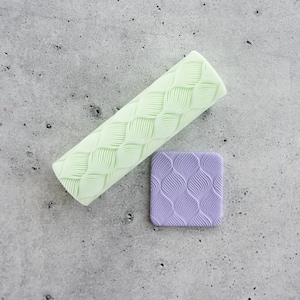 May include: A set of two silicone rolling pins with a leaf pattern. The larger rolling pin is light green and the smaller rolling pin is purple.