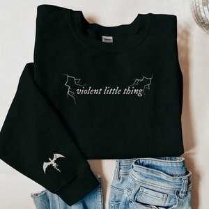 May include: Black sweatshirt with a white graphic of a lightning bolt and the text "violent little thing".
