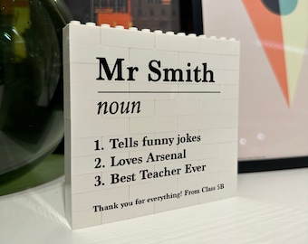 May include: White Lego brick block with black text that reads "Mr Smith noun 1. Tells funny jokes 2. Loves Arsenal 3. Best Teacher Ever Thank you for everything! From Class 5B"