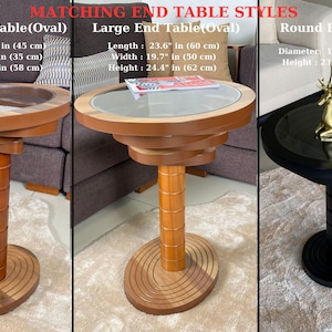 May include: Three end tables in different sizes and styles. The small table is oval shaped with a brown wood base and a glass top. The large table is also oval shaped with a brown wood base and a glass top. The round table has a black base and a glass top with a gold deer figurine on top. The tables are all on a beige carpet.