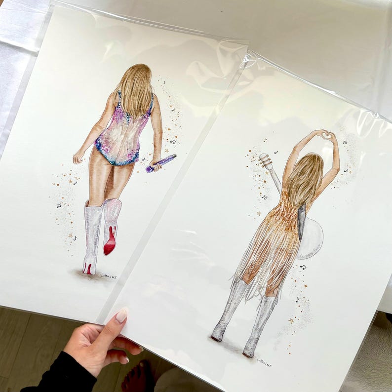 May include: Two watercolor art prints featuring figures from behind. The left print shows a person in a sequined bodysuit and white boots holding a microphone. The right print shows a person in a gold fringe dress and white boots making a heart shape.