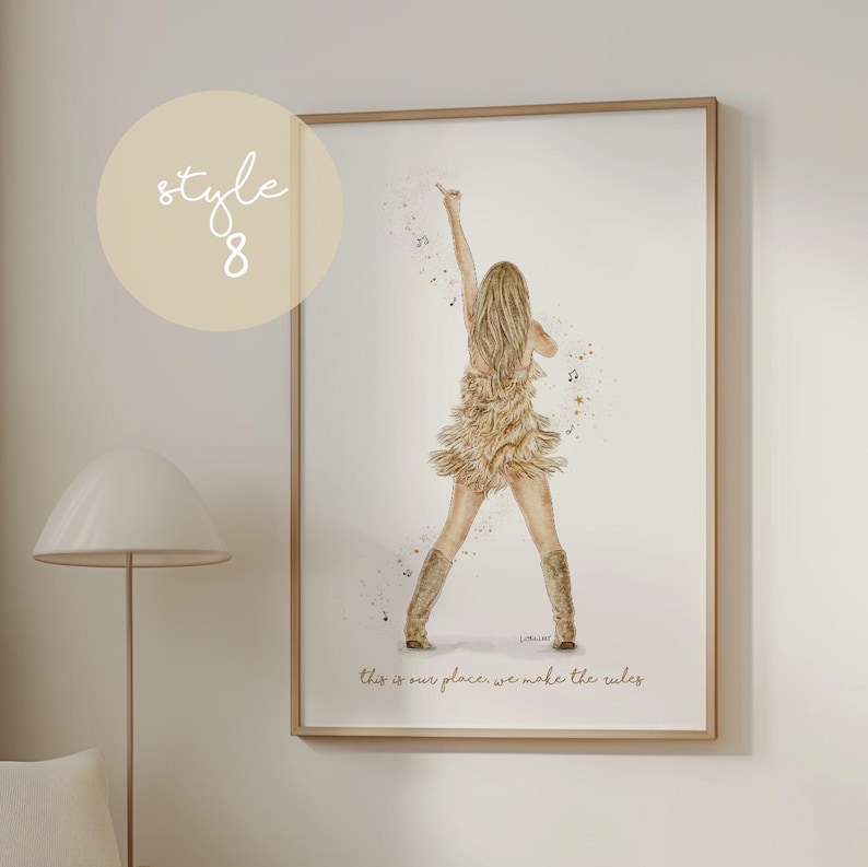 May include: Watercolor print of a woman in a fringed dress and boots, raising an arm. The artwork is in a wooden frame, with the text "this is our place, we make the rules" at the bottom. A light beige circle with the text "style 8" is in the upper left.
