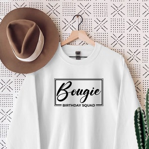 Könnte beinhalten: Weißer Pullover mit schwarzem Text, der "Bougie Birthday Squad" in einem Kasten sagt.