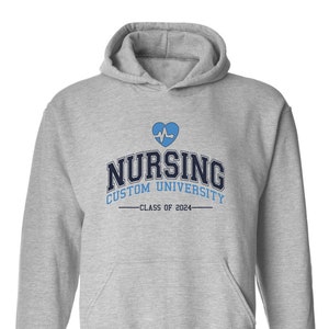 May include: Grey hooded sweatshirt with a blue heart and EKG graphic, the text "Nursing Custom University -Class of 2024-"