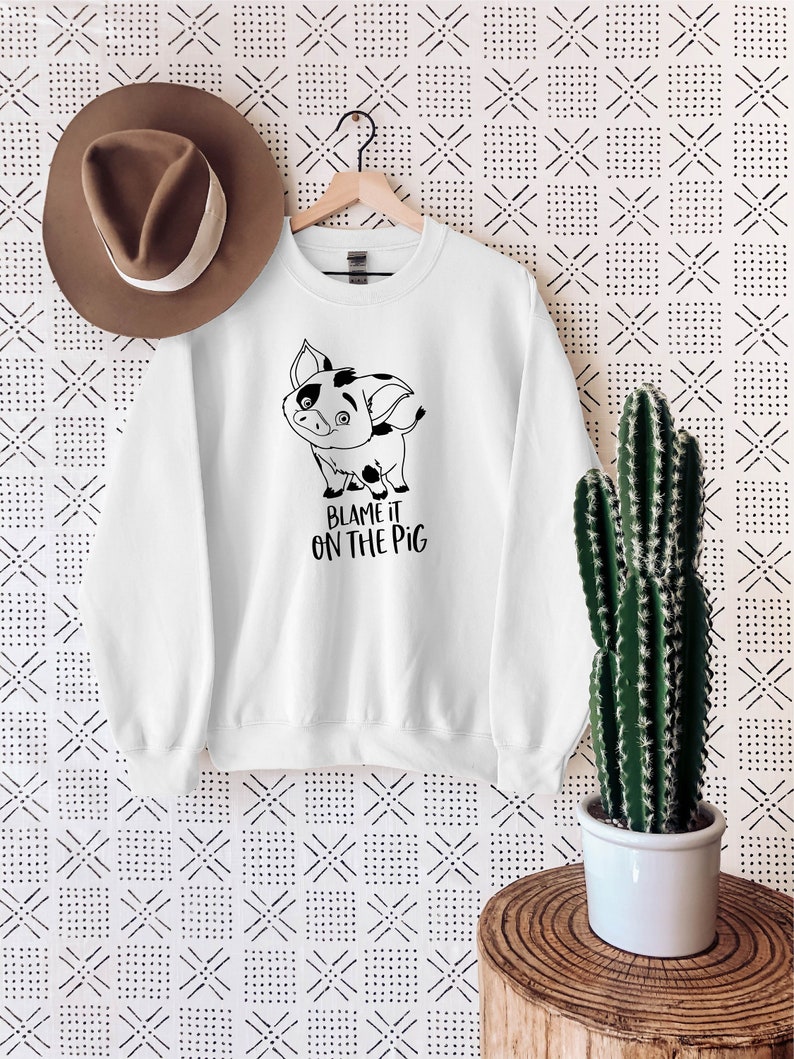 Puede incluir: Sudadera blanca con un cerdo de dibujos animados en blanco y negro y el texto "Blame it on the pig".