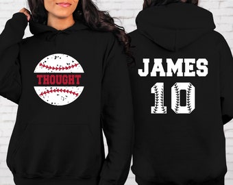 May include: Black hoodie with a white baseball graphic on the front and the text "THOUGHT" on the baseball. The back of the hoodie has the name "JAMES" and the number "10" in white with a baseball stitch design.