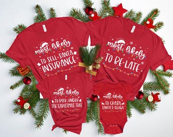 May include: Red Christmas-themed t-shirts and a onesie with white text. The shirts say "most likely to sell Santa insurance", "most likely to be late", and "most likely to peek under the Christmas tree". The onesie says "most likely to crash Santa's sleigh".