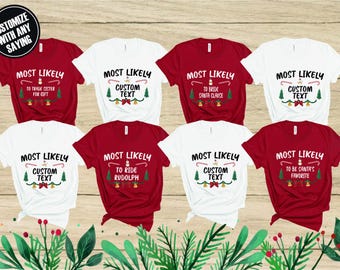 May include: A collection of red and white t-shirts with Christmas-themed text. The shirts feature phrases like "Most Likely to Trade Sister for Gift" and "Most Likely to Ride Rudolph". The shirts have a festive design.