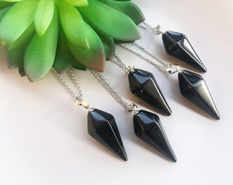 May include: Five black obsidian point pendants on silver chains. The pendants are faceted and have a pointed tip. The chains are delicate and have a silver clasp.