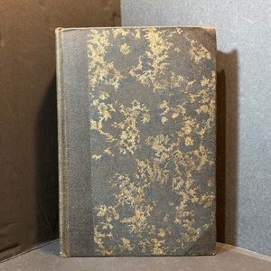 May include: A dark brown hardcover book with a gold and black patterned design on the cover.