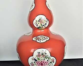 A Chinese colorful gourd-shaped vase. Decorated with floral motifs. Orange-red. Decorations on white background in red, blue, green